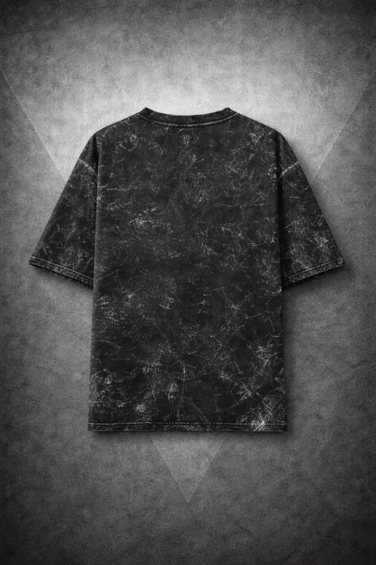 Black oversized t-shirt with distressed marble texture on geometric gray background, streetwear style